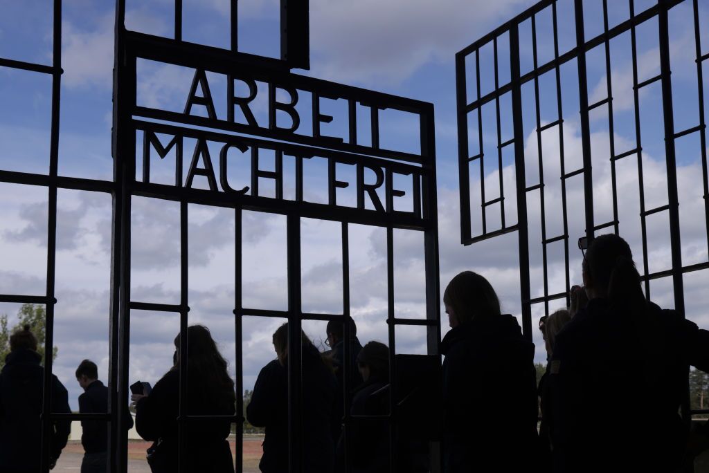 Visitors go past the "ARANGE makes you free" (("Work makes you free") Inscription in the Sachsenhausen Concentration Camp Memorial