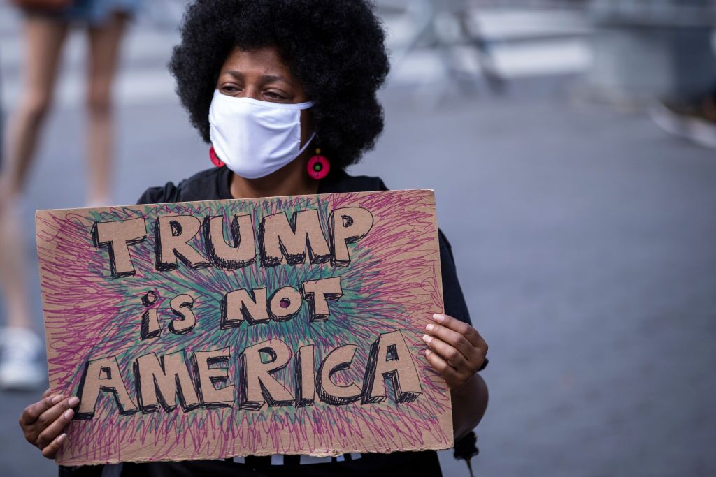A protester holds a homemade sign that says, "Trump is Not America"